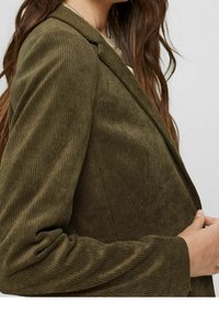 Oliwkowy blazer z korduru o chropowatej fakturze, z dopasowanym krojem, klapami w wycięciu oraz zapięciem na jeden guzik.