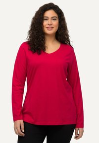 Langärmliges V-Ausschnitt-Shirt in leuchtendem Rot, aus glattem Stoff gefertigt. Verfügt über eine lockere Passform mit geradem Saum und weicher Textur.