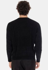 Maglione nero a maniche lunghe realizzato in morbido tessuto a maglia testurizzato. Presenta una scollatura tonda e polsini a coste. Vista posteriore che mostra una vestibilità comoda e colore uniforme.