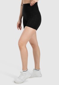 Zwarte high-waisted shorts van rekbaar materiaal, met een gladde textuur en een aansluitend ontwerp, voorzien van zijzakken.