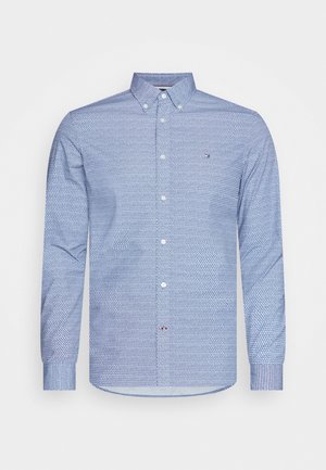 Blaues Langarmhemd mit kleinem geometrischem Muster, geknöpftem Kragen und dezentem Logo auf der linken Brust.