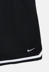 Μαύρο αθλητικό σόρτς από υφασμάτινο υλικό με υφή, με λευκό λογότυπο Nike και λευκές ρίγες κατά μήκος του τελειώματος.