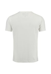 Camiseta blanca de manga corta, vista desde la parte posterior, con un sutil estampado en la etiqueta del cuello visible a través de la tela.