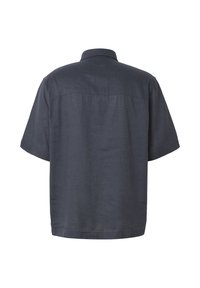 Chemise gris foncé à manches courtes, coupe ample et ourlet droit, vue de dos sur fond blanc.