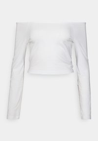 Top branco, com decote à laço, manga longa, feito de algodão suave, com um design que se ajusta ao corpo e comprimento cropped, apresentando uma textura suave.