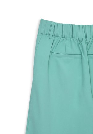 Helle Türkishosen mit elastischem Bund, Falten und einer Gesäßtasche. Hergestellt aus glattem Stoff und mit minimalen Nähdetails versehen.