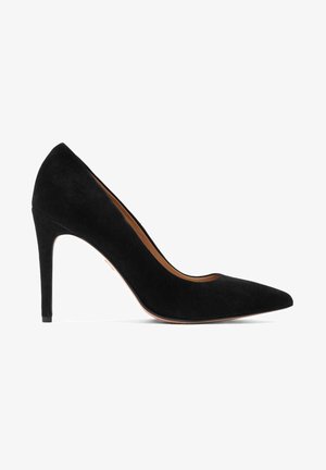 Escarpin noir en daim à talon haut avec une pointe effilée et une silhouette élégante. Présente une texture lisse et un talon aiguille fin.