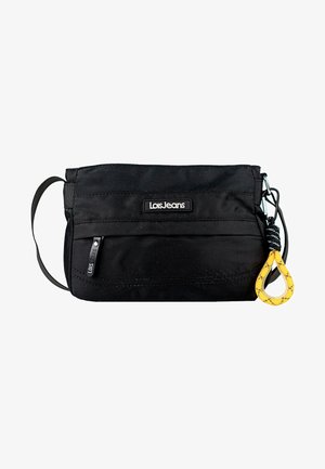 Bolsa de nylon negra con un bolsillo frontal con cremallera, que presenta un parche con el logo, una correa y un acento en forma de bucle amarillo. Textura suave y forma rectangular.