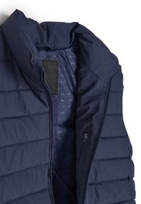 Granatowa ocieplana kamizelka z wysokim kołnierzem, z zamkiem błyskawicznym i boczną kieszenią. Gładka tekstura, pikowany wzór na zewnątrz.