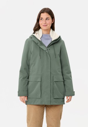 Veste imperméable verte avec une doublure en polaire blanche texturée, capuche ajustable et deux poches avant, présentant une coupe droite et des fermetures à boutons.