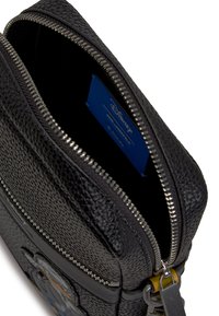 Black leather bag with a textured finish, featuring a zippered closure, inner label, and decorative hardware accents.