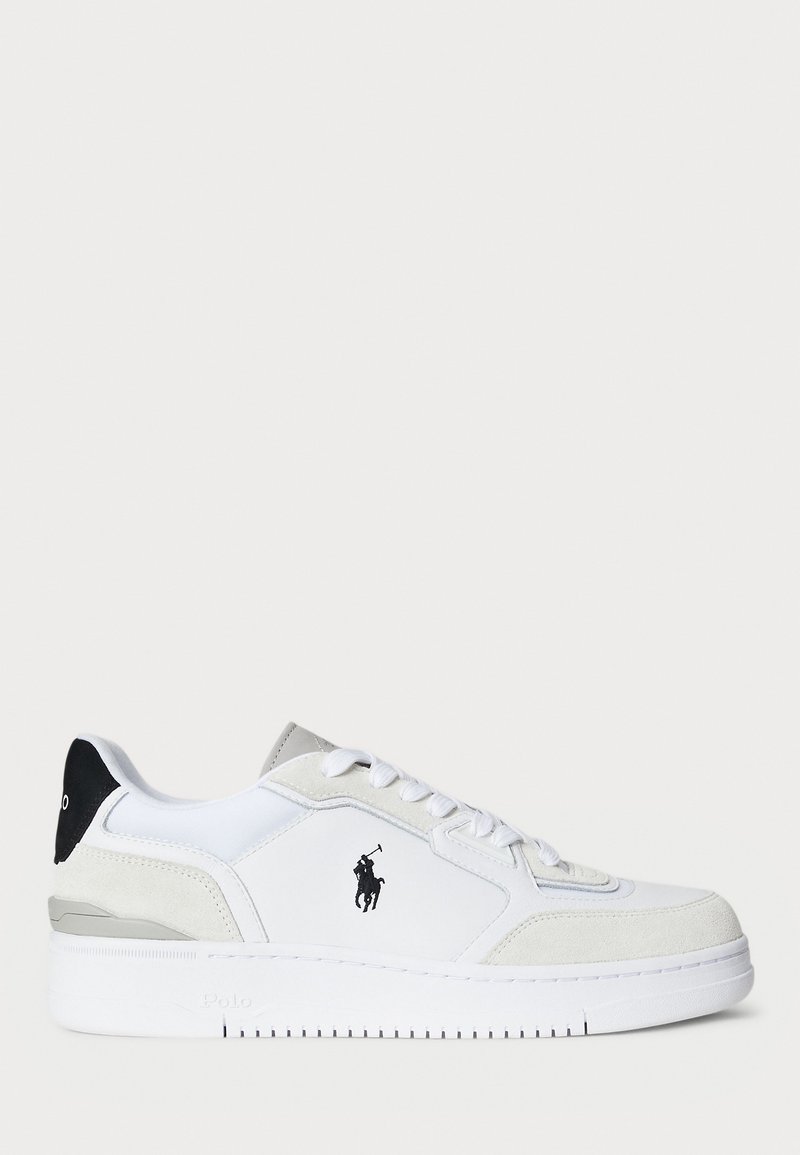 White sneaker with suede and leather upper, black heel accent, flat laces, logo on the side, and textured sole.