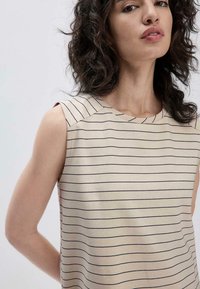Beige mouwloos topje met marineblauwe horizontale strepen, voorzien van een bootnek en een subtiele schoudernaad detail. Gladde stof textuur.
