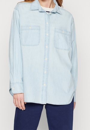Lichtblauwe denim shirt met lange mouwen, knopen aan de voorkant, twee borstzakken en een casual pasvorm. Zachte textuur met een licht vervaagde uitstraling.