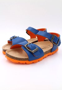 Sandales synthétiques bleues avec deux sangles ajustables dotées de boucles métalliques, une semelle en liège marron et une semelle en caoutchouc orange.