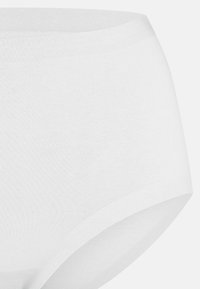 Culottes en coton blanc avec une texture lisse, dotées d'une taille mi-haute et d'une conception couvrante. Bords sans couture pour un look épuré.