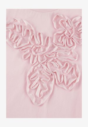 Roza tkanina s petimi tridimenzionalnimi, v obliki cvetlic narejenimi nagubami, prišito na površino, ki ustvarjajo teksturirane cvetne vzorce.