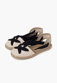 Sandali espadrillas in tela con toma beige chiaro, cinturini incrociati neri e suola in stile juta; presenta design con retro aperto.