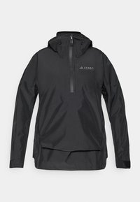 Schwarze, leichte Pulloverjacke mit hohem Kragen, halbem Reißverschluss vorne, verstellbare Kapuze und Logodetail auf der Brust. Glattes, wasserfestes Material.