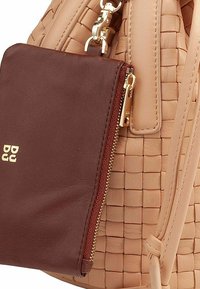 Borsa in pelle intrecciata beige con una pochette zip in bordeaux removibile, dotata di accessori in oro e dettagli testurizzati sul corpo principale.