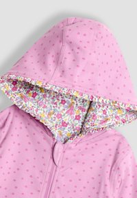 Rosa Kapuzensweatshirt mit floralem Muster im Innenfutter der Kapuze und kleinen Blumen auf der Außenseite. Mit Reißverschluss vorne.