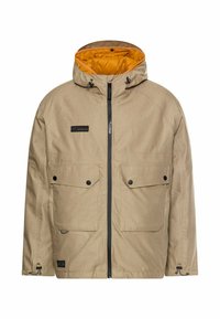 Beige jakke med hætte, med en gul foring. Inkluderer to frontlommer med klapper, en frontlynlås og justerbare snore.