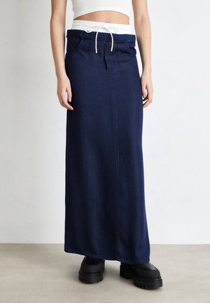 Jupe maxi en denim bleu foncé avec une taille élastique et un cordon de serrage blanc, dotée de deux poches latérales et d'une silhouette droite.