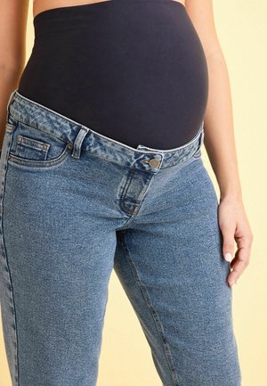 Jeans de maternidad en denim azul claro con una cinturilla negra elástica. Presenta bolsillos delanteros y un cierre estándar con cremallera/botón.