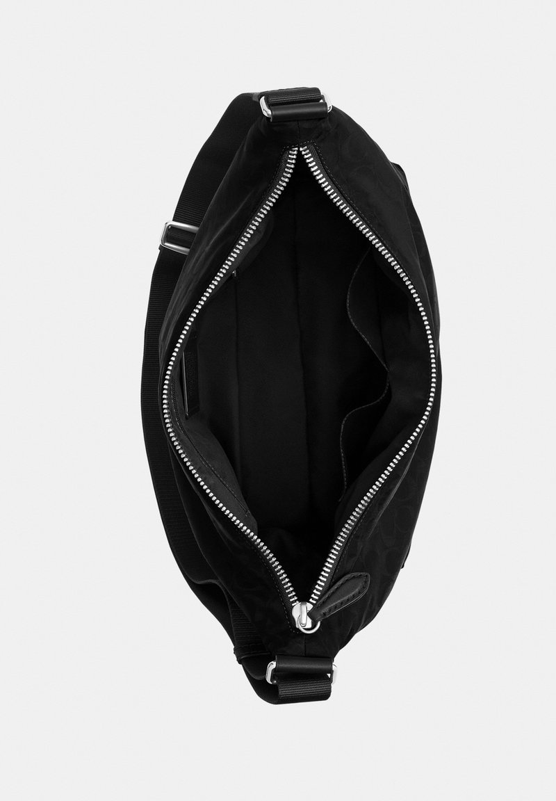 Black sling bag with wide adjustable strap and top silver zipper partially open showing a spacious black interior with inner pocket.