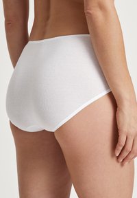 Culotte blanche en coton taille haute avec une texture douce et une taille élastique, présentant un design sans couture au niveau des ouvertures de jambes.