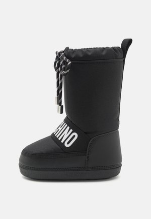 Sort vinterstøvle med snøre-lukning, mærket elastikrem over fronten med teksten "MOSCHINO" og tekstureret sål.
