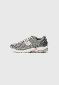 Gray athletic shoe featuring a mesh upper with synthetic accents, cushioned sole, and a reflective logo. Designed for comfort and support.