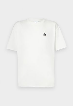 Tricou alb din bumbac cu mâneci scurte, având un logo triunghiular negru pe pieptul stâng. Guler clasic rotund, croială lejeră.