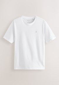 T-shirt bianca a maniche corte con collo rotondo e piccolo logo grigio di cervo sul petto sinistro, etichettata Next, taglia media, vestibilità regolare.