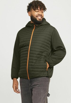 Chaqueta verde acolchada con un frente acolchado, cremallera naranja en contraste y capucha. Presenta bolsillos laterales y un corte relajado.