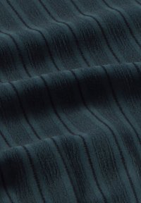 Tessuto caratterizzato da un tessuto verde scuro con sottili strisce ondulate in una texture più morbida, creando un aspetto stratificato.