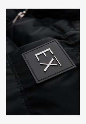 Schwarzes Puffy-Jackett aus glänzendem Material. Verfügt über ein rechteckiges schwarzes Label mit eingeprägter metallic-silberner Schrift "EX".
