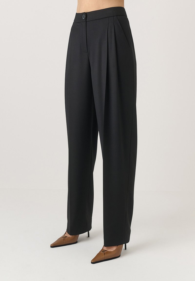 Fekete szabott nadrág magas derékkal, elején redőzéssel és egy gombos zárással. Az anyag simának tűnik, jól definiált sziluettel.