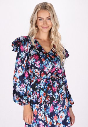 Blomstret bluse med marineblå baggrund og livlige pink, blå og orange mønstre. Lange ærmer med flæser og v-hals design.
