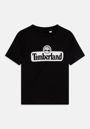 T-shirt nera in cotone, con il logo bianco "Timberland" e grafica dell'albero centrata sul petto. Collo a giro e maniche corte.