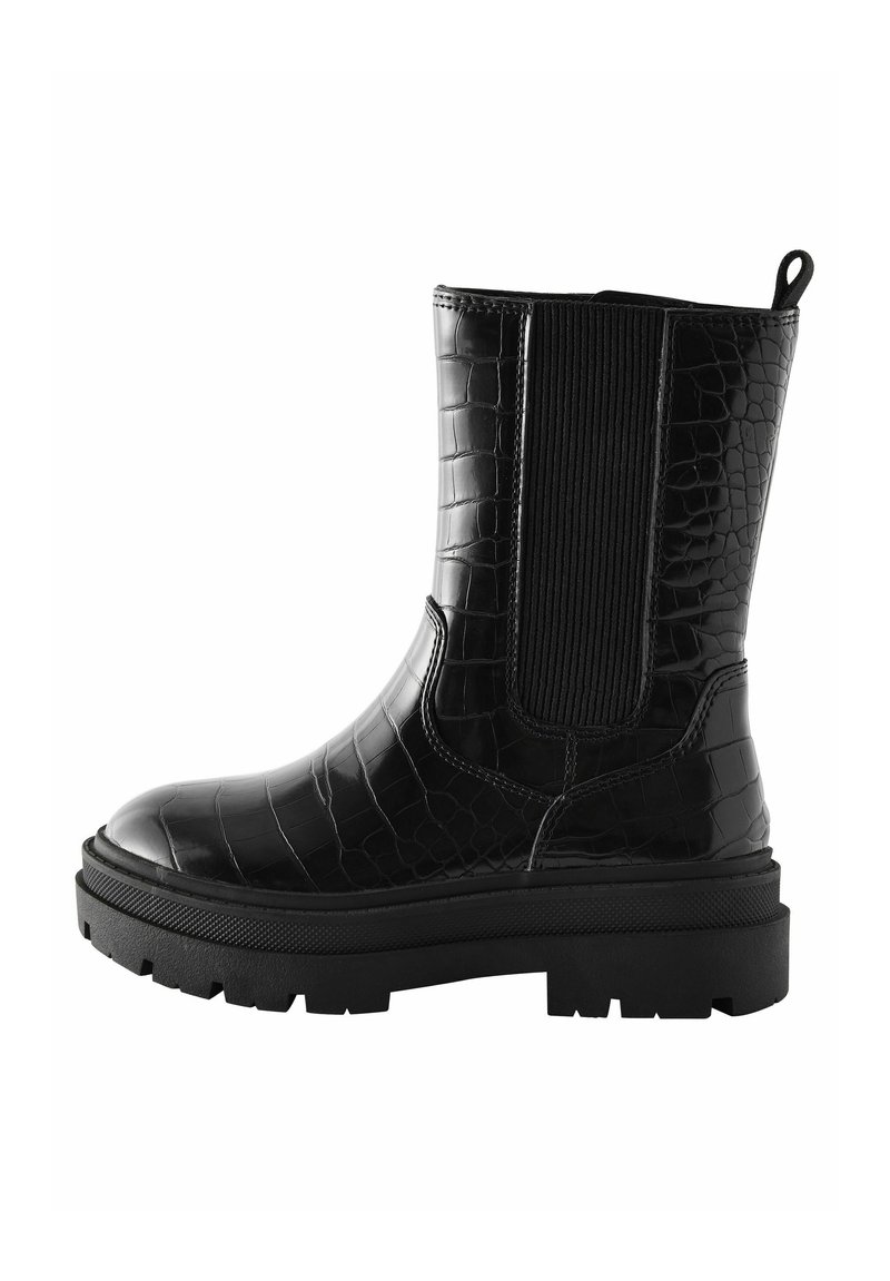 Schwarze Knöchelstiefel aus glänzendem, krokodilgeprägtem Material, mit einer dicken Sohle, elastischen Seitenpaneelen und einer Schlaufe an der Rückseite.