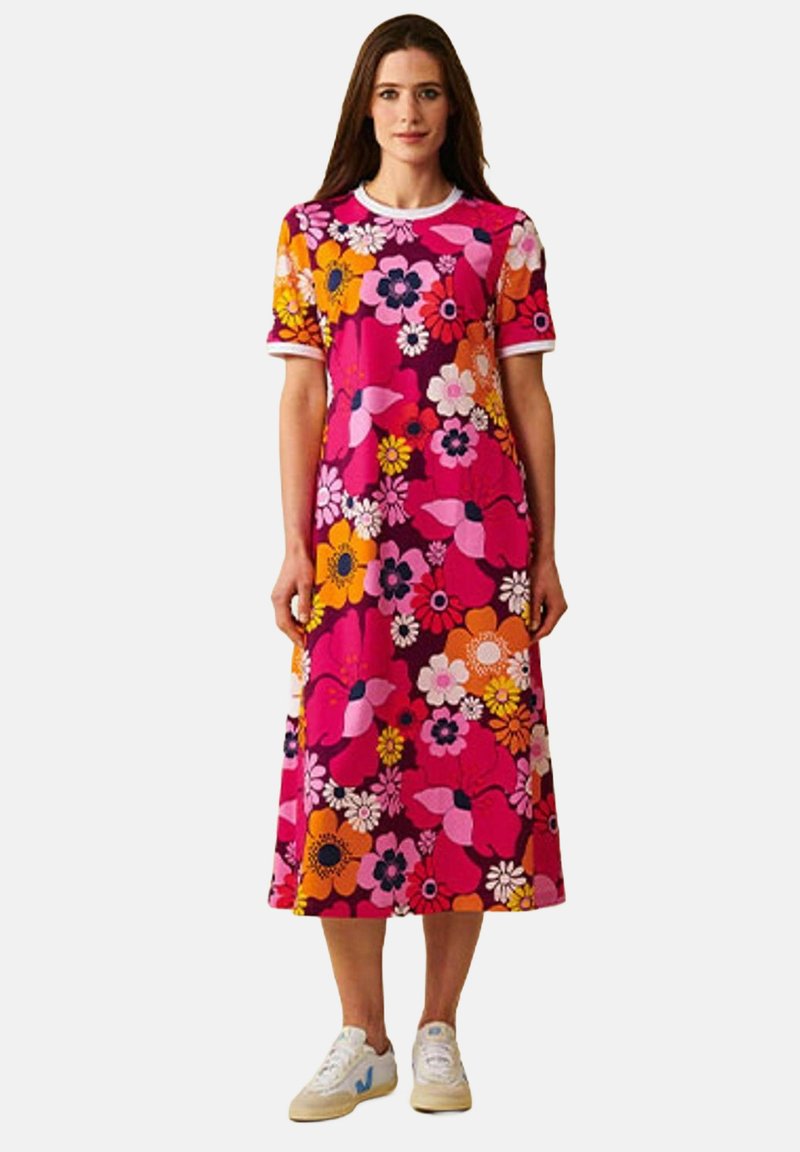 Kukallinen mekko vaaleanpunaisena, oranssina ja valkoisena. Lyhyet hihat valkoisella reunuksella. Midi-pituus ja flouncy siluetti. Rentoa tyyliä.