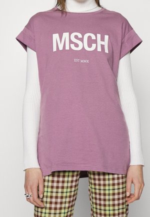 T-shirt en coton lavande avec manches courtes retroussées, avec texte blanc « MSCH EST MMX » sur le devant, associé à un pantalon à carreaux marron et vert.
