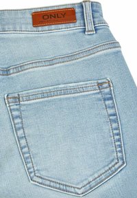 Lichtblauwe denim jeans met een enkele achterzak, contrasterende stiksels en een leren label in bruin met "ONLY" erop geperst.