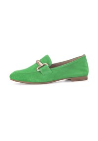 Groene suede instappers met een lage hak, voorzien van een decoratieve metalen gesp en een zachte binnenvoering. De platte zool zorgt voor comfort.