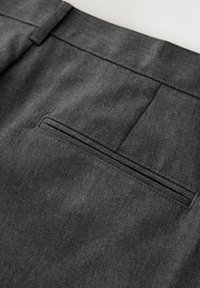 Pantalon en tissu gris foncé avec une poche passepoilée à l'arrière et une couture sur la ceinture, montrant une texture et des coutures détaillées.