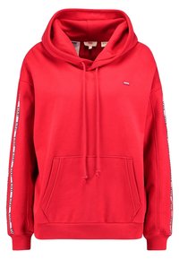 Red hoodie made of cotton blend, featuring a kangaroo pocket, drawstrings, and branded tape along the sleeves. Soft texture, relaxed fit.