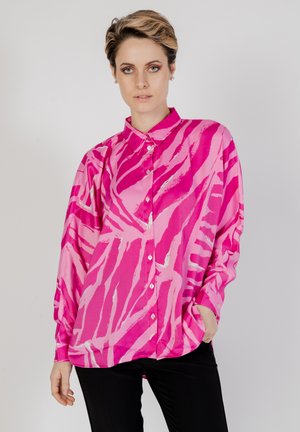 Camicia button-up di un brillante colore rosa con strisce bianche astratte, maniche lunghe e tessuto morbido. La camicia presenta un colletto classico e una vestibilità ampia.