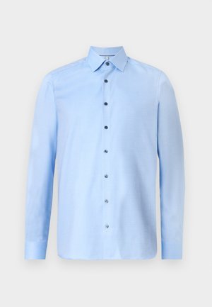 Chemise bleu clair à manches longues en tissu texturé, dotée d'un col classique et de boutons foncés contrastants sur le devant.