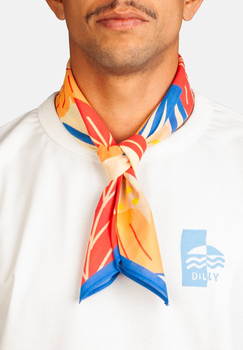Ein Mann trägt ein weißes Hemd mit einem blauen "Dilly"-Logo und einen lebhaften, mehrfarbigen Schal in rot, orange, blau und gelb, der um seinen Hals gebunden ist.